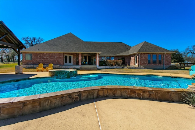 pool with an in ground hot tub and a patio