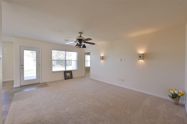 unfurnished living room with baseboards, visible vents, and light colored carpet