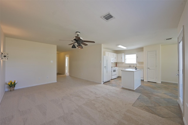 kitchen featuring white appliances, visible vents, white cabinetry, open floor plan, and light countertops