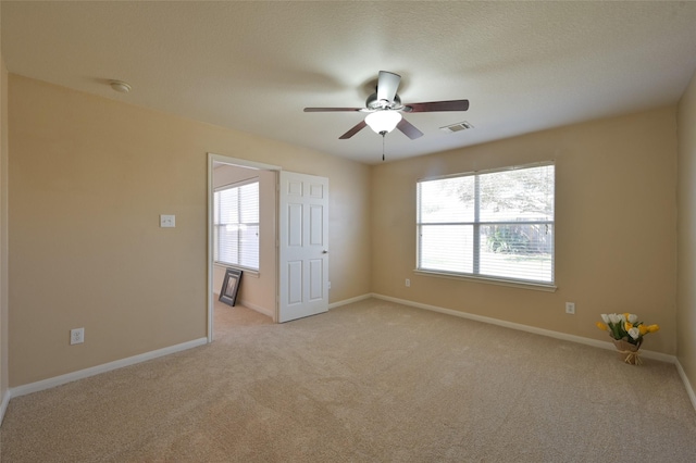 unfurnished room featuring ceiling fan, light carpet, and baseboards