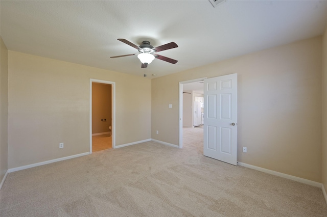 unfurnished bedroom with light carpet, baseboards, and ensuite bathroom