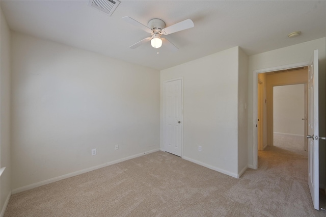 unfurnished room featuring light carpet, a ceiling fan, visible vents, and baseboards