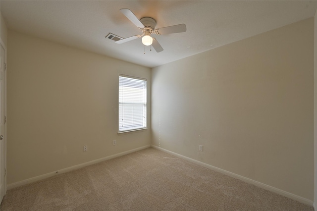 unfurnished room featuring light carpet, a ceiling fan, visible vents, and baseboards