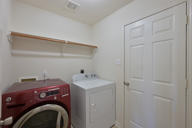 washroom featuring laundry area, visible vents, and washer and dryer