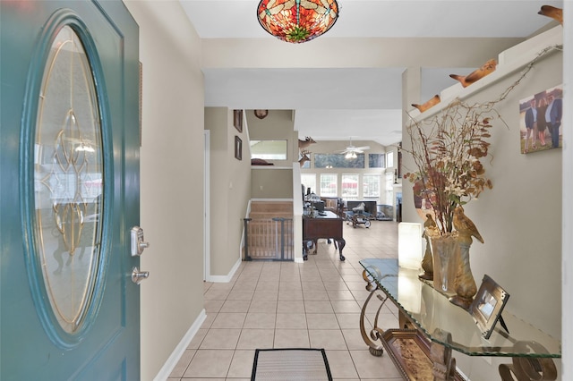 entrance foyer with a ceiling fan, light tile patterned flooring, and baseboards