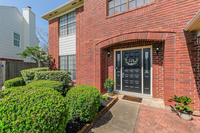 entrance to property with fence and brick siding