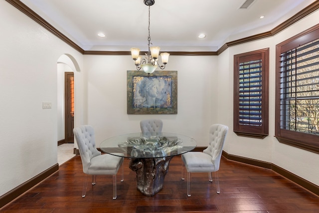 dining room with a healthy amount of sunlight, baseboards, arched walkways, and hardwood / wood-style floors