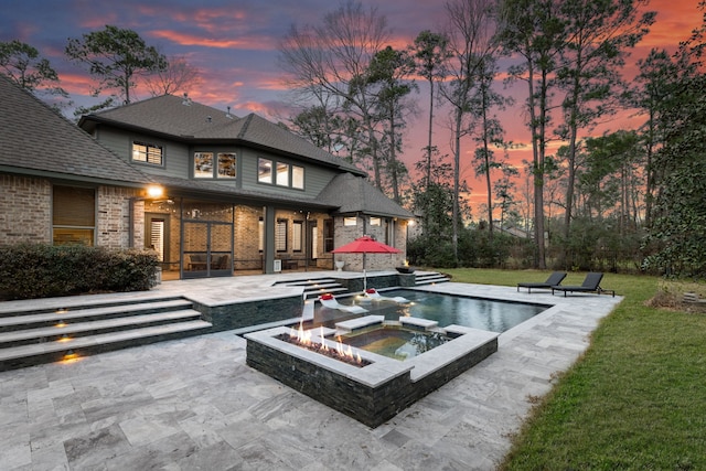 exterior space featuring a patio, a yard, brick siding, and an outdoor pool