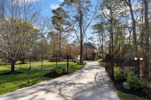 view of community with a fenced front yard and a yard