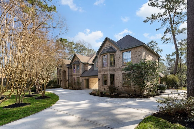 view of front facade featuring concrete driveway and brick siding