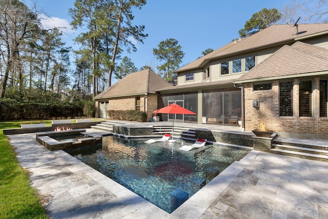 view of pool with a sunroom, a patio area, and a pool with connected hot tub