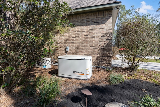 details featuring a power unit, brick siding, and a shingled roof