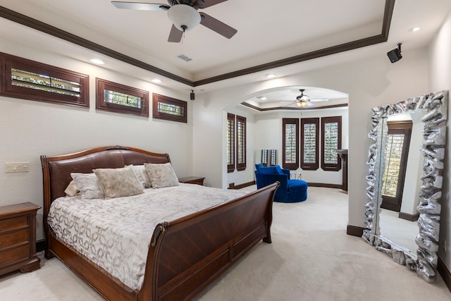 bedroom featuring visible vents, arched walkways, baseboards, light colored carpet, and a tray ceiling