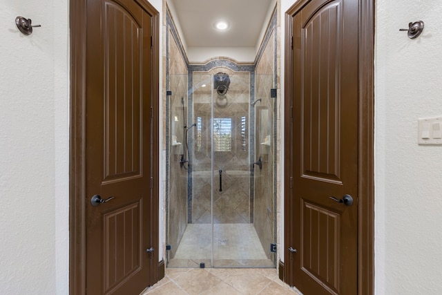 bathroom with a stall shower and tile patterned flooring