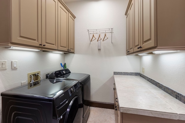 laundry room featuring light tile patterned floors, cabinet space, baseboards, and separate washer and dryer