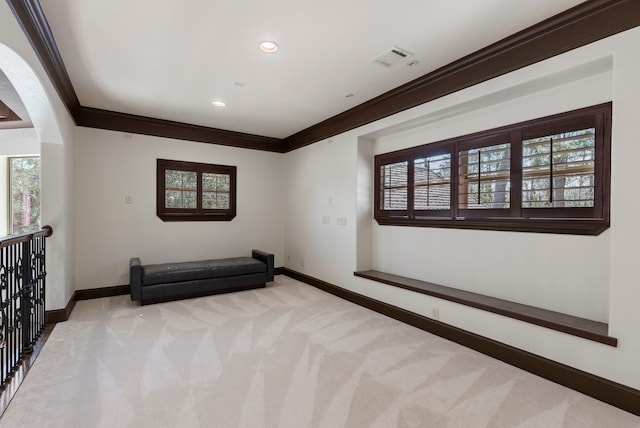 unfurnished room with light carpet, crown molding, visible vents, and baseboards