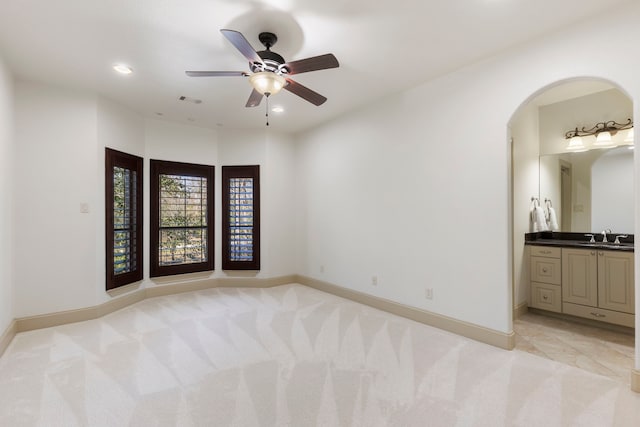 spare room featuring light carpet, visible vents, baseboards, a sink, and recessed lighting