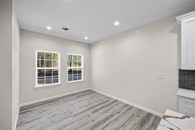 interior space with light wood finished floors, recessed lighting, visible vents, and baseboards