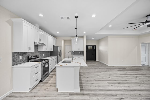 kitchen with visible vents, hanging light fixtures, appliances with stainless steel finishes, white cabinetry, and a sink