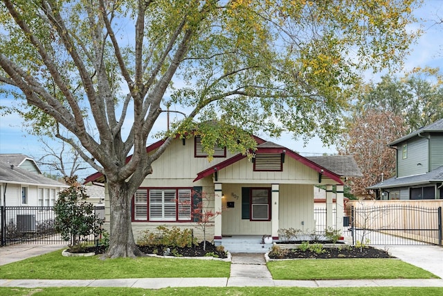 view of front of house featuring a fenced front yard, a gate, a front lawn, and a porch