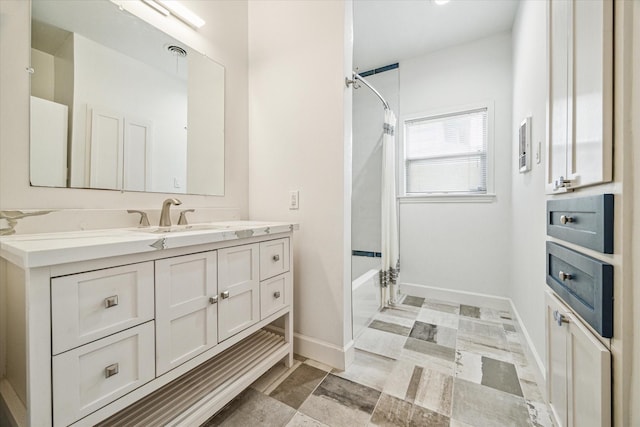 full bath featuring visible vents, shower / bath combo, vanity, and baseboards