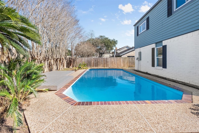 view of pool featuring a fenced in pool, a patio area, a fenced backyard, and a wooden deck