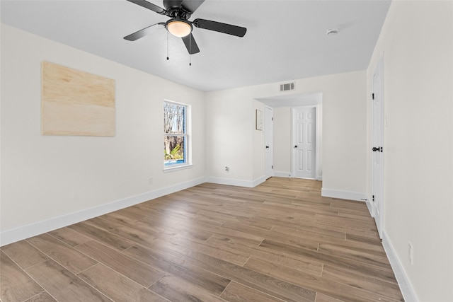 unfurnished room featuring light wood finished floors, visible vents, and baseboards