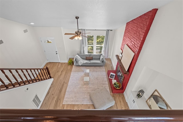 living area with visible vents, baseboards, and wood finished floors