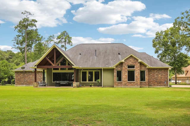 back of property featuring a patio area, a lawn, and brick siding