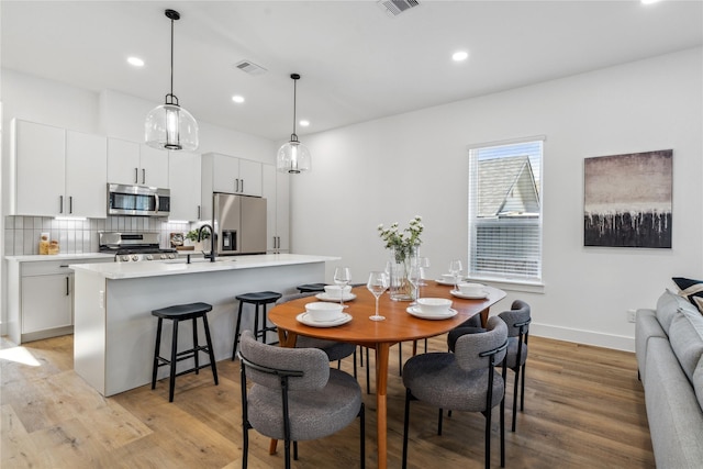 dining space featuring light wood finished floors, visible vents, and recessed lighting