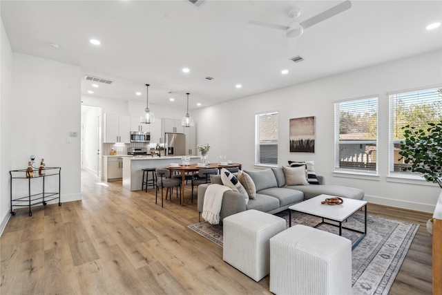 living room with recessed lighting, visible vents, and light wood-style flooring