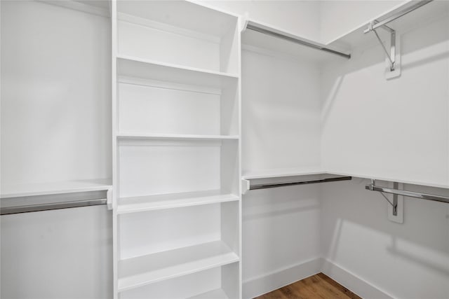 walk in closet with wood finished floors