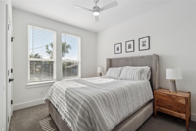 bedroom featuring dark colored carpet, a ceiling fan, and baseboards