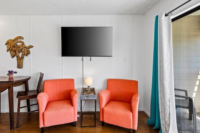 sitting room with dark wood-style floors and a textured ceiling