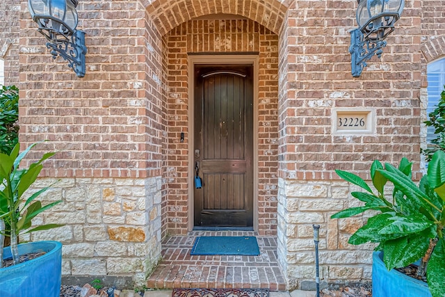 doorway to property featuring brick siding