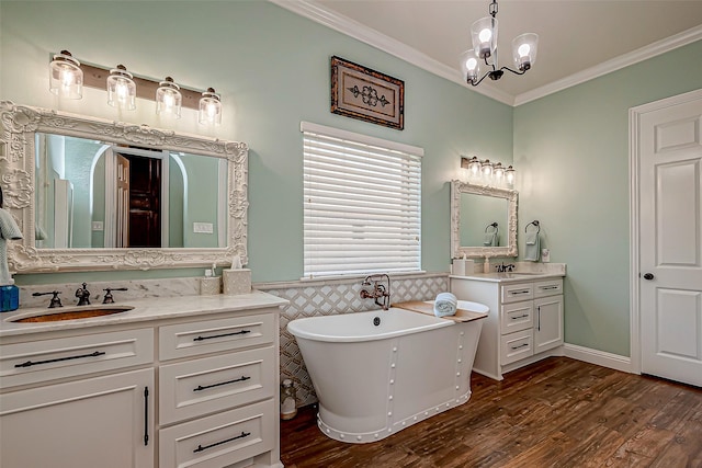 bathroom featuring a sink, a wainscoted wall, crown molding, and wood finished floors