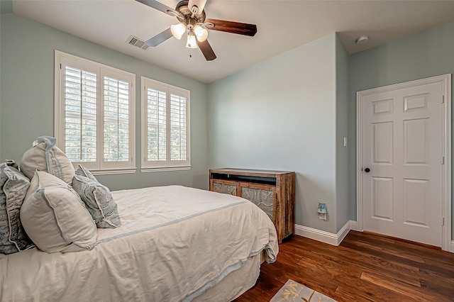 bedroom featuring dark wood-style floors, baseboards, visible vents, and a ceiling fan