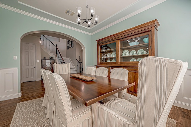 dining area with arched walkways, visible vents, a notable chandelier, and stairs