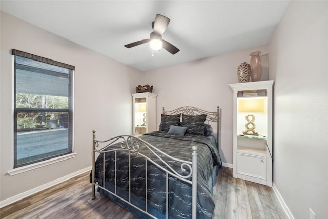 bedroom featuring ceiling fan, baseboards, and wood finished floors