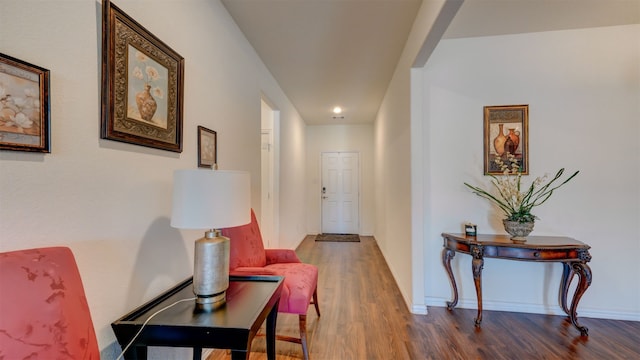 corridor with wood finished floors and baseboards