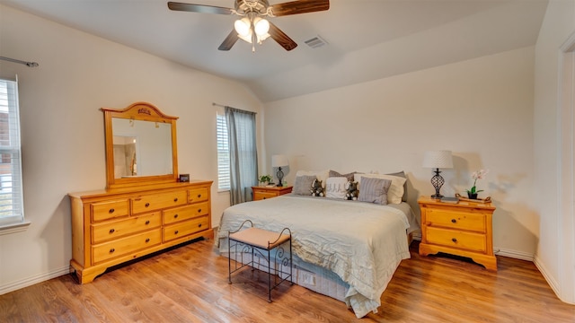 bedroom with visible vents, baseboards, lofted ceiling, ceiling fan, and light wood-style floors