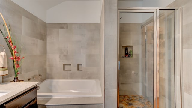 full bathroom featuring vanity, a bath, and a shower stall