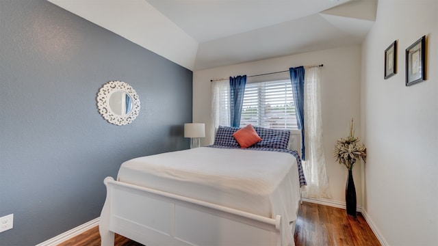 bedroom with baseboards and wood finished floors