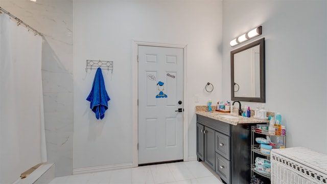 full bath with vanity and baseboards