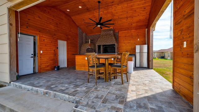 view of patio / terrace with a ceiling fan, outdoor dining space, and an outdoor fireplace