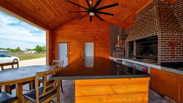 kitchen with lofted ceiling, brown cabinetry, wooden ceiling, and wooden walls