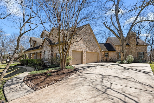 view of front of house with a garage, stone siding, and concrete driveway