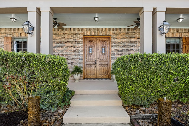 property entrance with covered porch, brick siding, and ceiling fan