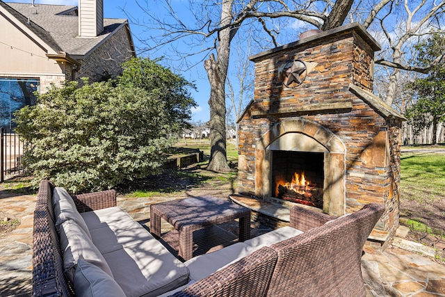 view of patio / terrace featuring fence and an outdoor living space with a fireplace