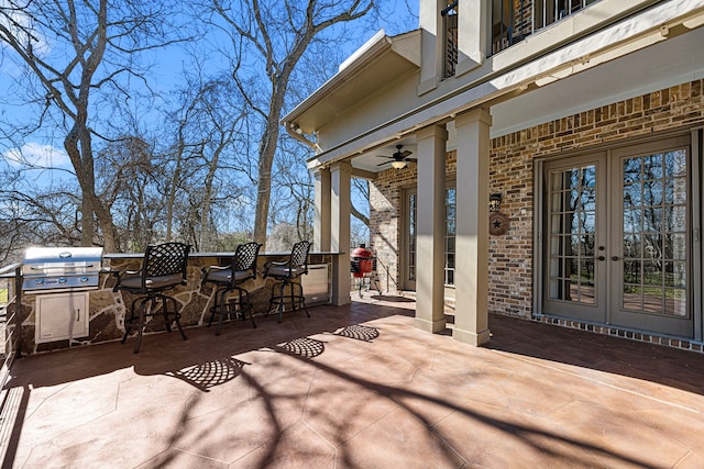 view of patio / terrace with ceiling fan, area for grilling, outdoor dry bar, french doors, and grilling area